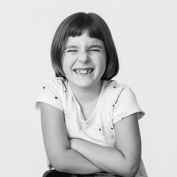 black and white of kid laughing with missing teeth and eyes squinting