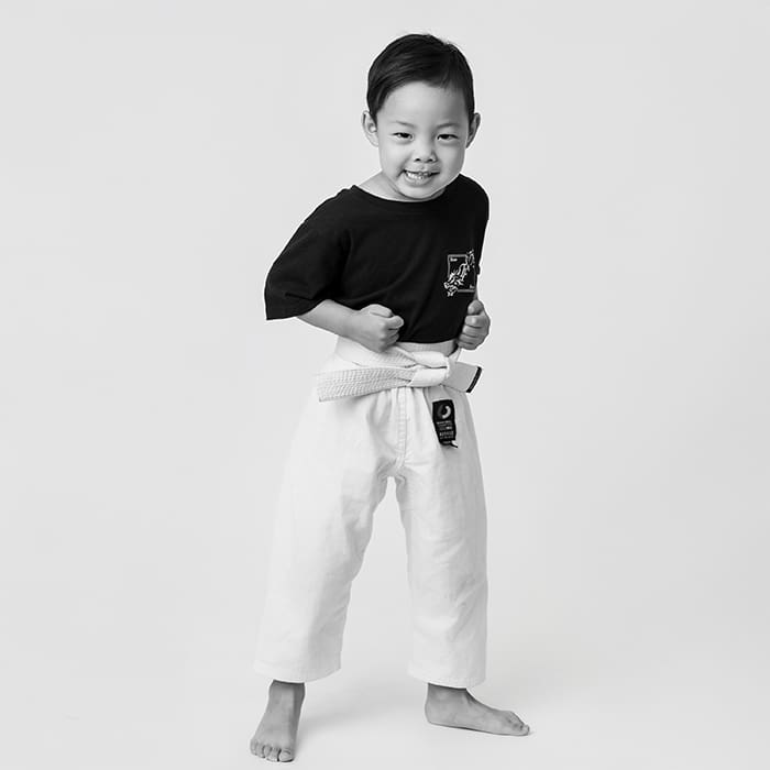 kid in karate uniform on white background with karate uniform on
