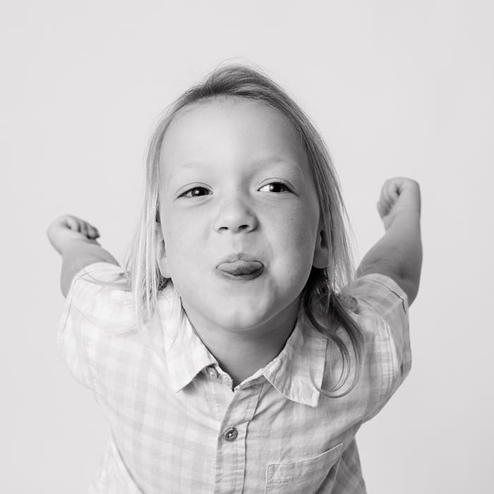 boy sticking tongue out pushing arms back in personality photo