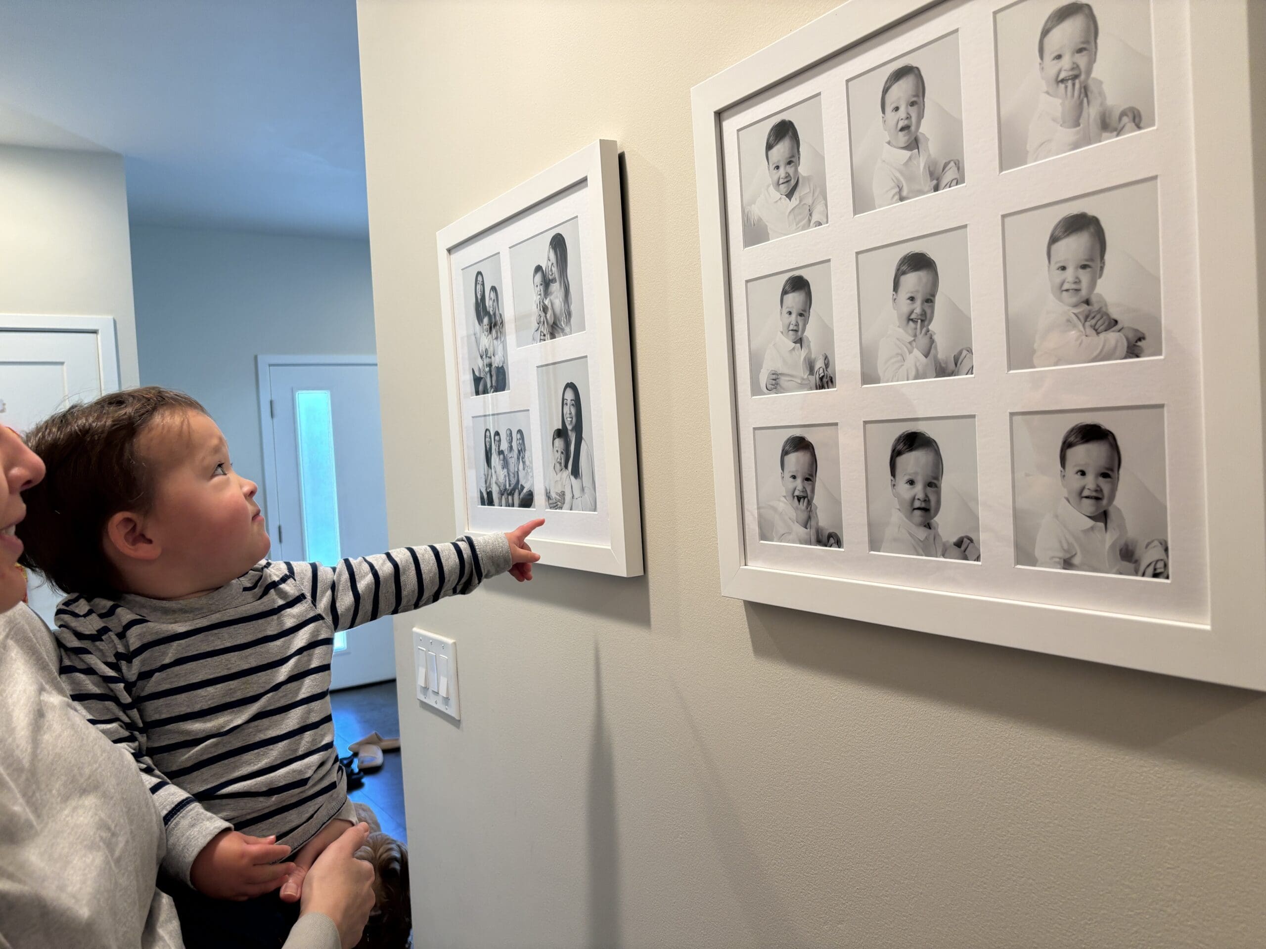 child looking at artwork on the wall of his pictures pointing to it