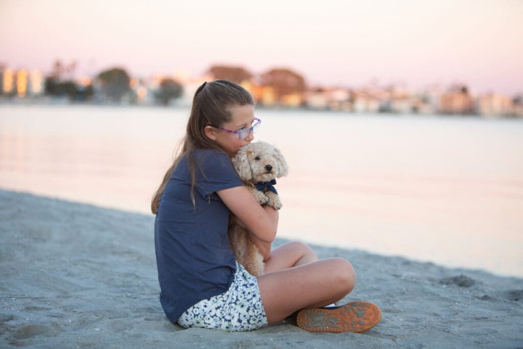 San diego family mission bay girl holding her dog kissing him