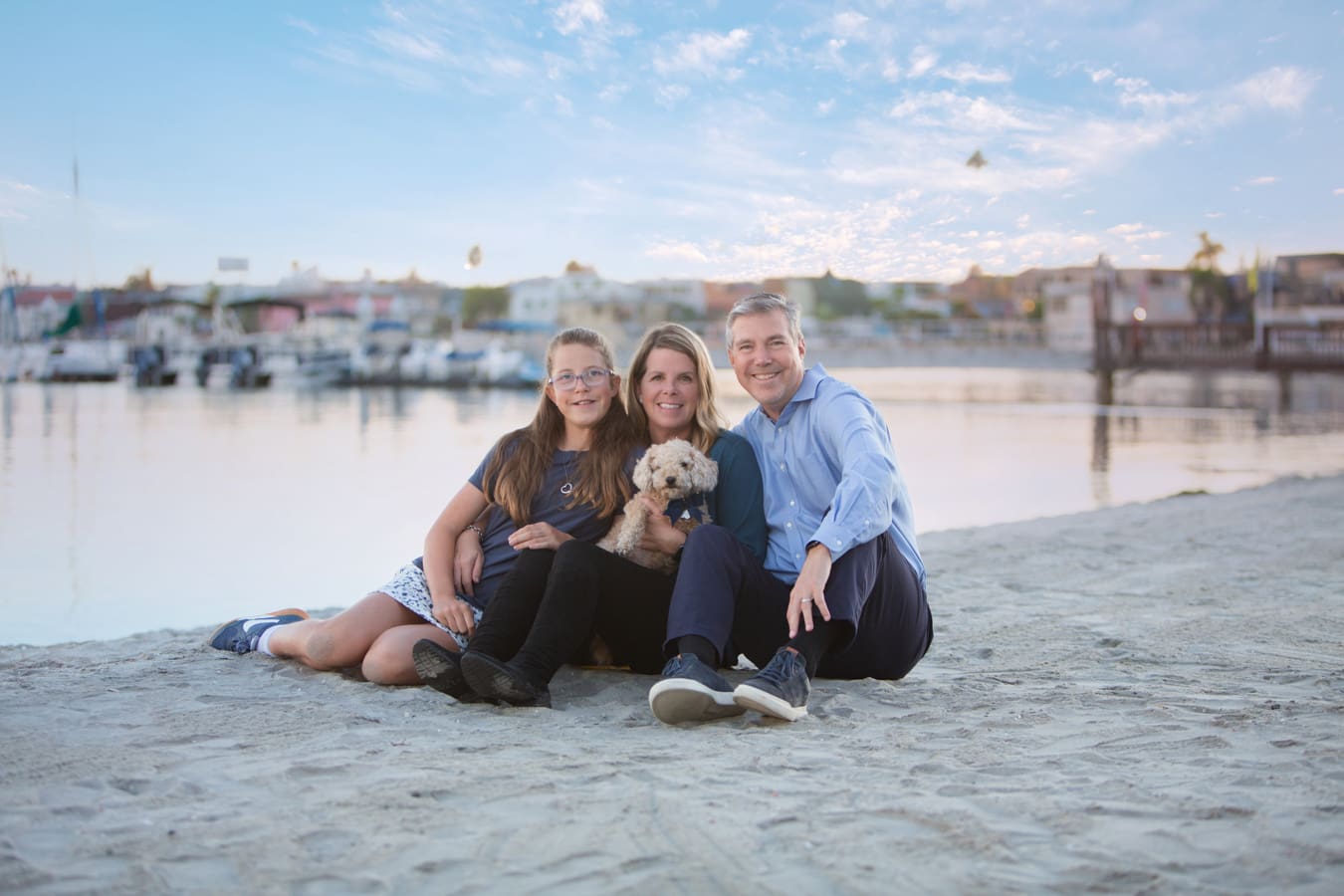 San diego family mission bay family of 3 sitting on the sand at the bay