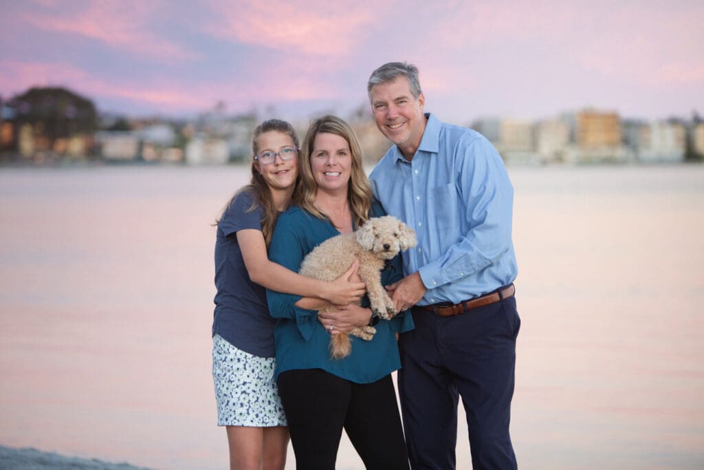 San diego family mission bay standing at the by holding their dog
